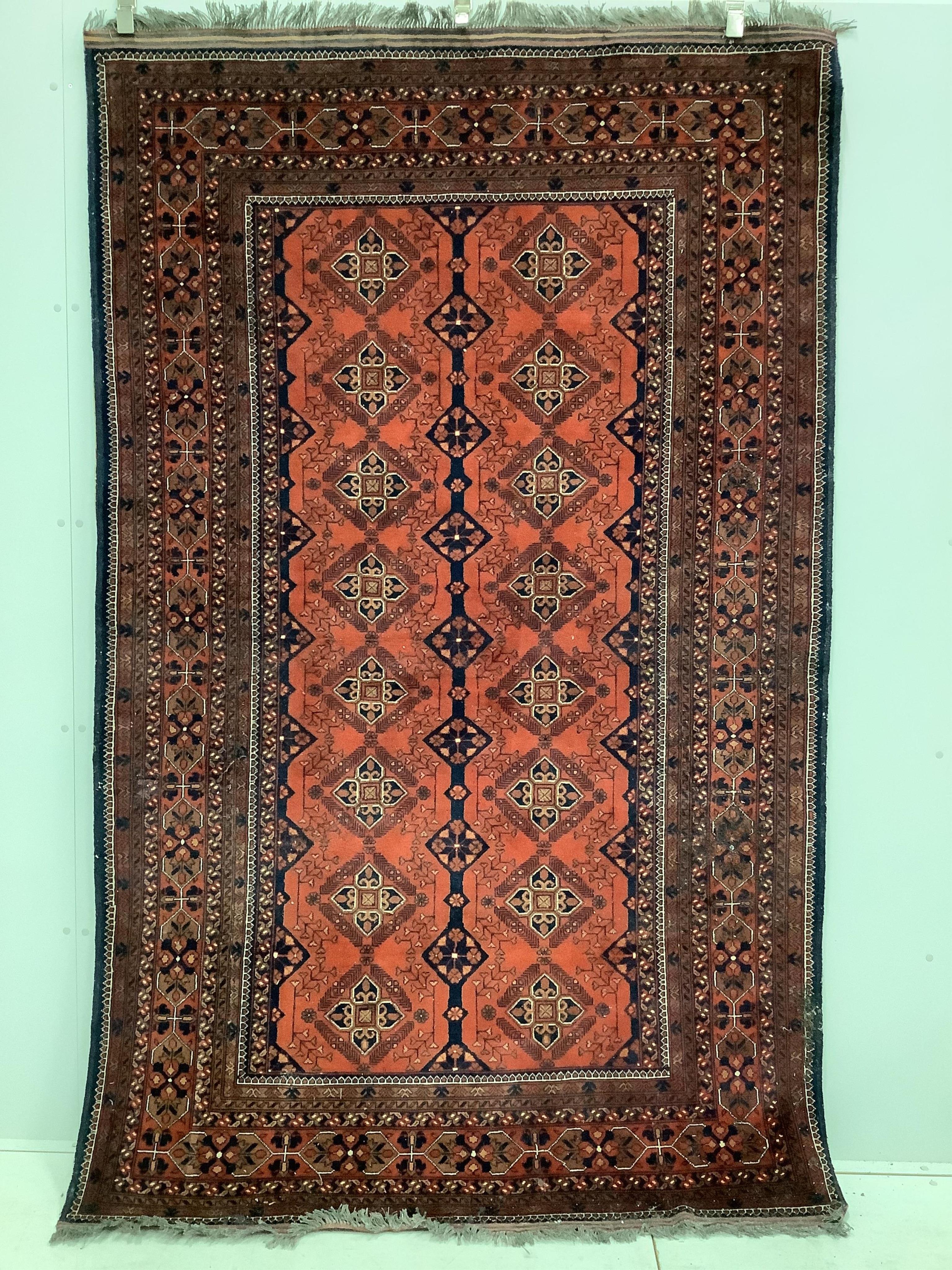 A ‘Khan Mohamadi’ Afghan red ground small carpet, woven with rows of lozenge devices, 240 x 152cm